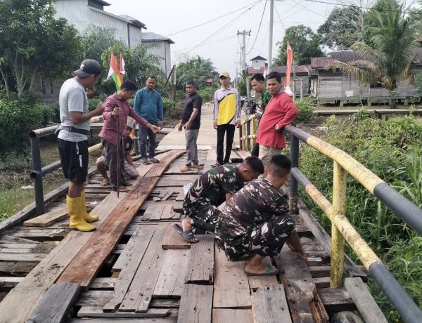 Perkuat Kemanunggalan TNI dan Rakyat, Satgas TMMD ke-129 Kodim 0313/KPR dan Warga Gotong Royong Perbaiki Jembatan jalan Desa