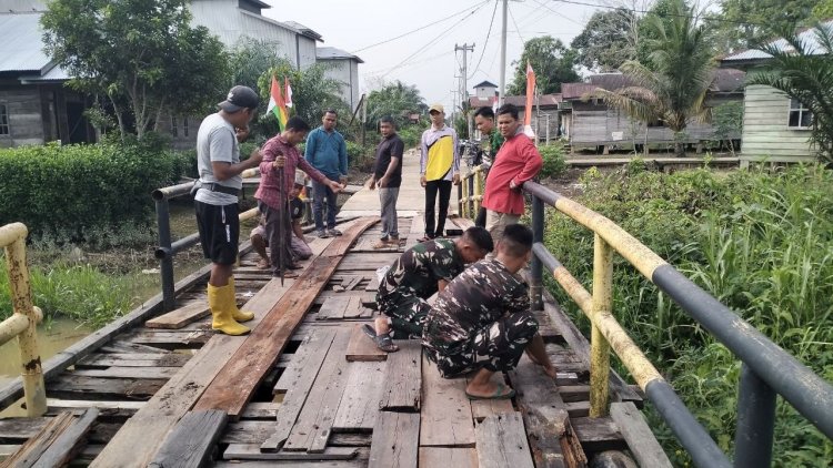 Perkuat Kemanunggalan TNI dan Rakyat, Satgas TMMD ke-129 Kodim 0313/KPR dan Warga Gotong Royong Perbaiki Jembatan jalan Desa